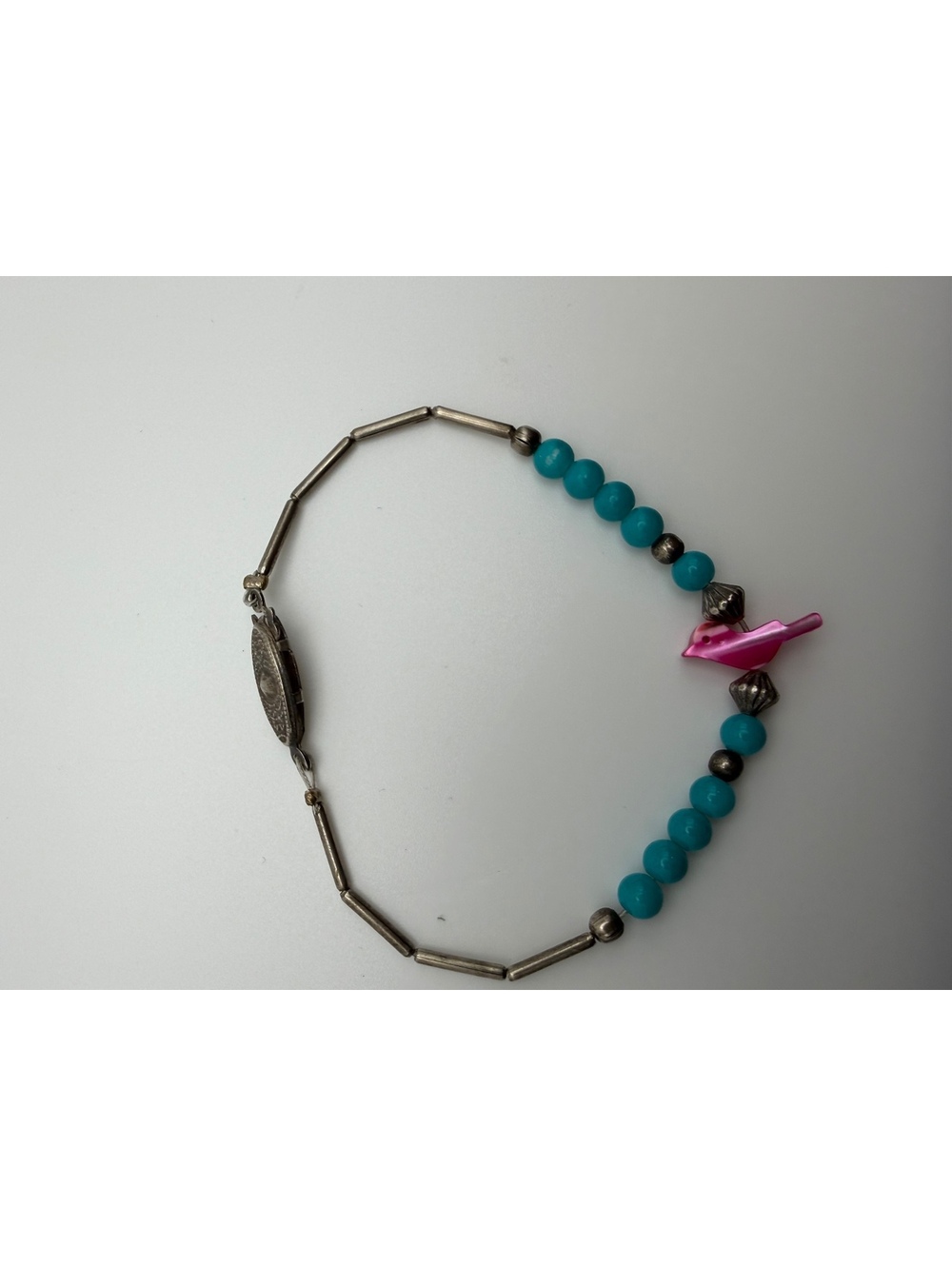 Turquoise bead and silver tone bracelet with pink bird charm